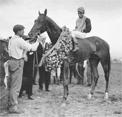 Moment image for Winner Judge Himes with jockey Harold Booker, trainer John P. Mayberry, and owner Charles R. Ellison.