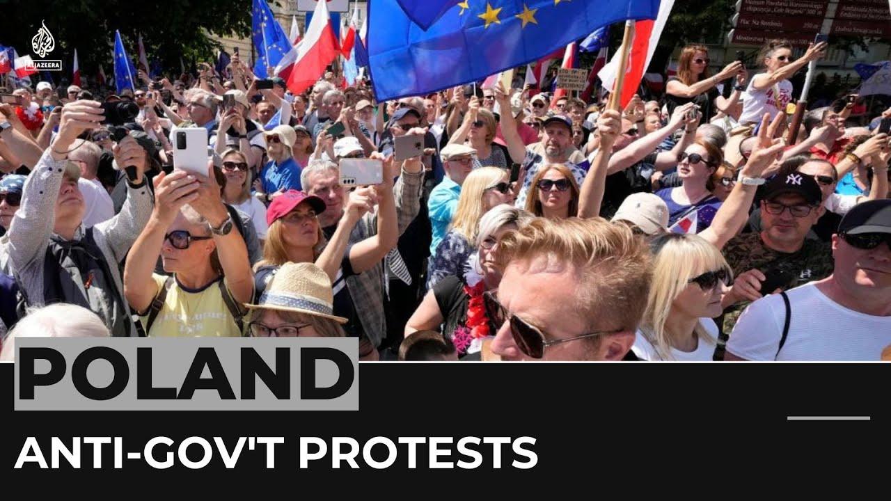 Moment image for Thousands of people march in opposition to the far-right government in Warsaw.